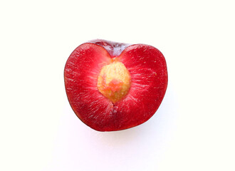 A halved Black Splendor Plum. So called because the flesh of this speciality plumb is so dark. Focus is on the deep beetroot red flesh of the fruit. 