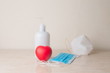 a gel soap 
sanitizer with some mask and a heart on a table