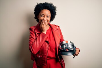 Young African American afro motorcyclist woman with curly hair holding motorcycle helmet laughing...