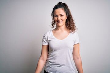 Obraz premium Young beautiful woman with curly hair wearing casual t-shirt standing over white background with a happy and cool smile on face. Lucky person.