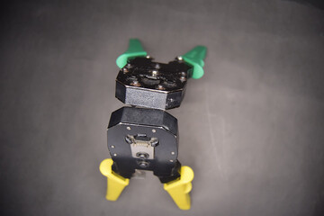 Yellow and green adjustable wire stripper joining head to head isolated on a black background,...