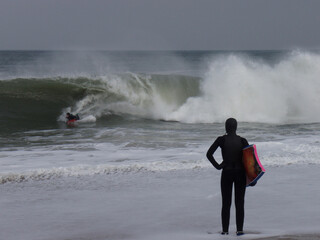 Girl standing and waiting to jump in during Noreaster surf in Delaware