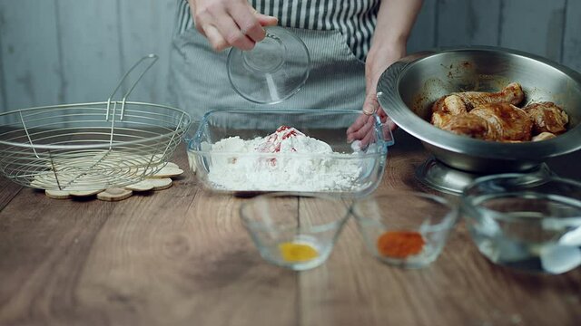 Adding flour into a glass bowl along with 1 TBSP of Salt, Soya sauce, Tomato Ketchup, Ginger paste, Garlic paste, Chilli paste, Black pepper powder. Concept of preparing the breading for juicy Chicken