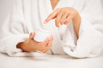 Fototapeta na wymiar Woman applies moisturizer cream for hand skin care