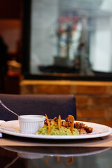 Plato de guacamole con arrachera y totopos