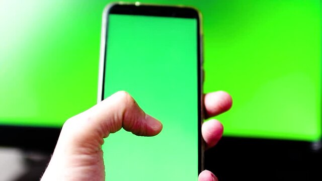 Segurando celular com fundo em verde