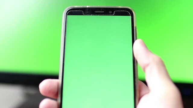 Segurando celular com fundo em verde