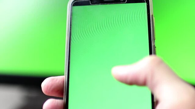 Segurando celular com fundo em verde