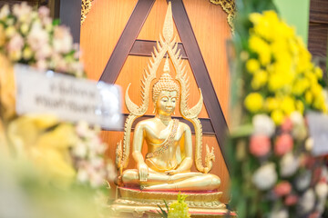 The blurred background of the Buddha statue with gold yellow color laying enshrined for religious ceremonies.