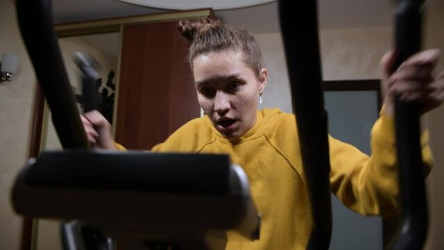 Hard home workout of a young woman who is sweating, wide angle