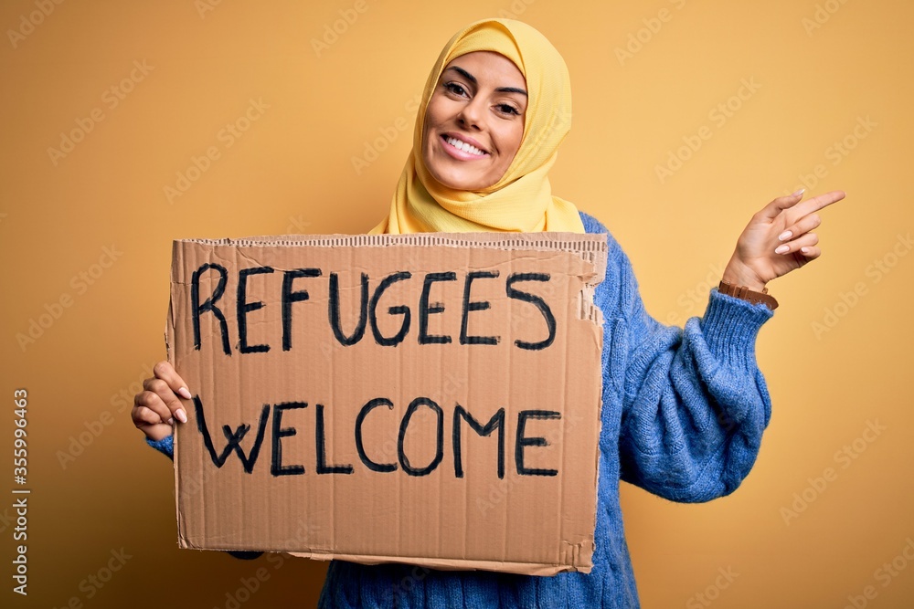 Sticker beautiful arab woman wearing islamic hijab holding banner with refugees welcome message very happy p