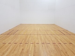 wood floor racquetball court with white walls