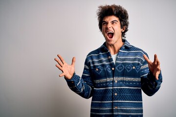 Young handsome man wearing casual shirt standing over isolated white background crazy and mad...