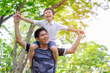 Happy and enjoy Asian Father and son having fun in summer park