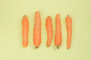 Fresh harvested carrots on a yellow background isolate. Vegetables Vitamins Keratin. Natural organic carrots lie on a colored background Top View Flat Lay. Rural Agriculture Concepts