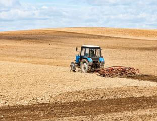 an old tractor plows the soil