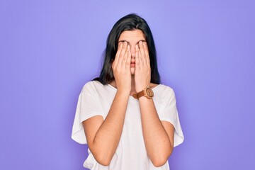 Young beautiful brunette woman wearing casual white t-shirt over purple background rubbing eyes for fatigue and headache, sleepy and tired expression. Vision problem
