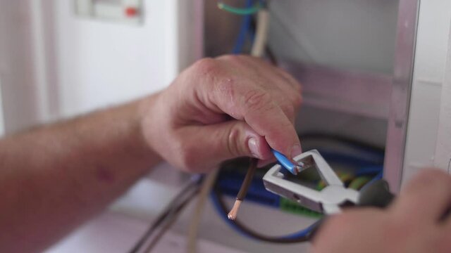 strip electrical wire with plier in electric instalation slow motion