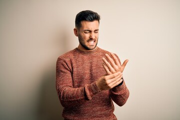 Young handsome man wearing casual sweater standing over isolated white background Suffering pain on...