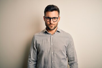 Young handsome man wearing elegant shirt and glasses over isolated white background skeptic and nervous, frowning upset because of problem. Negative person.