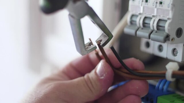 strip electrical wire with plier in electric instalation slow motion