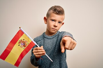 Young little caucasian kid flag from Spain over isolated background pointing with finger to the camera and to you, hand sign, positive and confident gesture from the front
