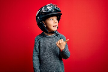 Young little caucasian kid wearing vintage biker motorcycle helmet and googles over red background...