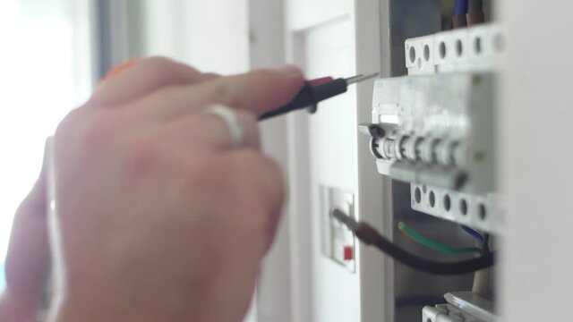 electrician using digital multimeter on electrical installation slow motion