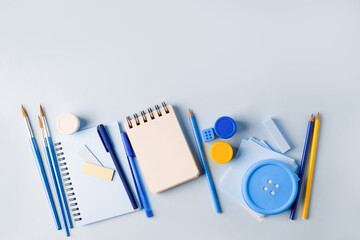 School supplies on blue board background. Back to school concept, monochrome stylish background, flat lay, mock up, design copy space