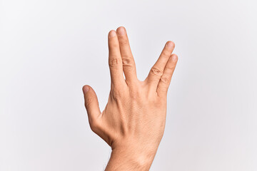 Hand of caucasian young man showing fingers over isolated white background greeting doing Vulcan salute, showing back of the hand and fingers, freak culture