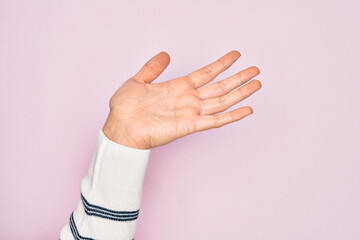 Hand of caucasian young man showing fingers over isolated pink background presenting with open...