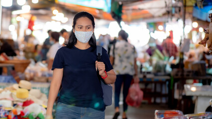 Portrait of Asia woman wearing mask shopping in the fresh market