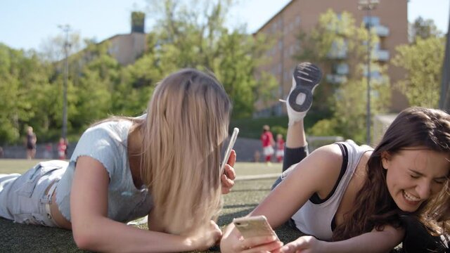 A teenage girl recording a TikTok prank video with her friend.