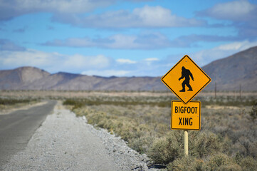 Comical sign on isolated desert highway that says "Bigfoot Crossing"