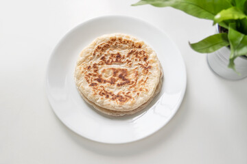 Close up of roti prata on a white plate