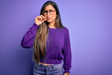Young beautiful smart woman wearing glasses over purple isolated background mouth and lips shut as...