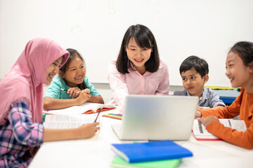 Asian female teacher teaching kid writing lesson and reading book in classroom, Special education during school holidays.