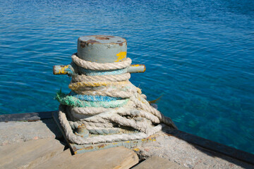 Shoreside bollard. Shoreside bitts with rope.
