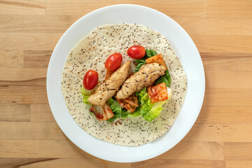 chicken breast wrap with kimchi, cherry tomatoes and vegetables