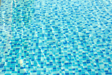Ripple Water in swimming pool with blue tile floor background