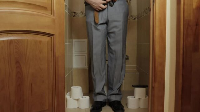 a man in a hurry and sits on the toilet