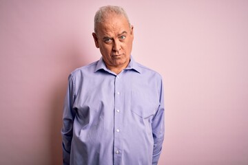 Fototapeta premium Middle age handsome hoary man wearing casual shirt standing over pink background depressed and worry for distress, crying angry and afraid. Sad expression.