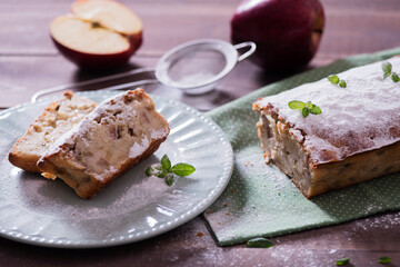 Homemade  apple pie on the green napkin decorated with fresh red  apples,, mint leaves. Vegetarian tart on the wooden background. Delicious autumn dessert.