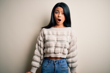 Young beautiful chinese woman wearing casual sweater over isolated white background afraid and shocked with surprise expression, fear and excited face.