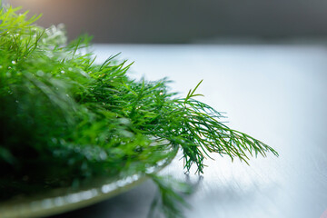 Fresh green dill branches, selective focus, close-up. Dill branches prepared for salad or freezing. Benefits of fresh greens for health.