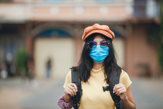 Asian woman backpacker wearing mask travel after pandemic of coronavirus, Young girl wearing hat backpack traveling in street.