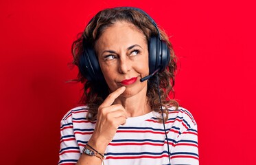 Middle age brunette gamer woman playing video game using headphones and microphone thinking...
