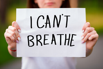 BLM Protest. Blurred Caucasian Girl With Paper Hold in Hand a Poster With the Message Text I CANT BREATHE , Concept on The Theme of Protest at Police Brutality.