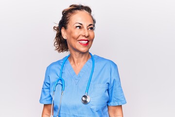 Middle age brunette nurse woman wearing uniform and stethoscope over white background looking to...