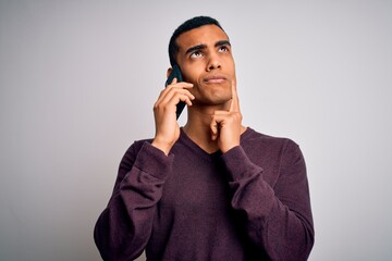 Young handsome african american man having conversation talking on the smartphone serious face...